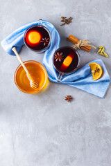 Mulled wine on gray background. Two glasses of autumn mulled wine on a blue napkin. Christmas hot drink. Copy space. Top view