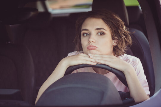 Photo Of Bored Unhappy Cute Young Woman Lady Driver Sleepy Sit Put Head Hands Steering Wheel Alone Car Drive Home Traffic Jam Bad News Upset Expression Wear Beige T-shirt Inside Auto Salon