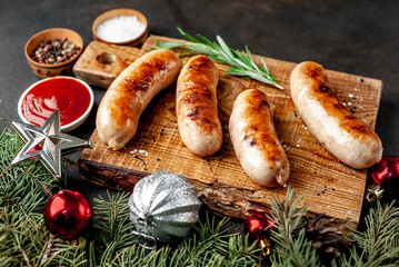 Christmas grilled sausages with spices on a stone background with Christmas trees and Christmas...