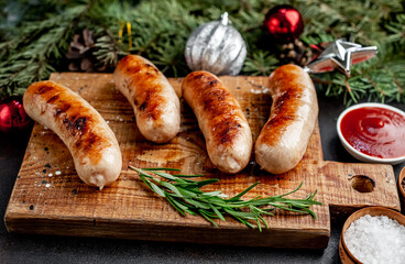 Christmas grilled sausages with spices on a stone background with Christmas trees and Christmas...