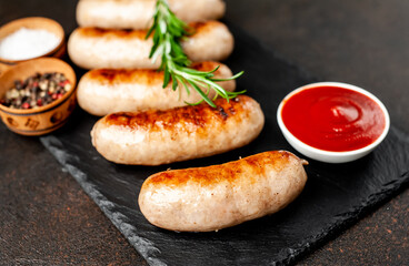 grilled sausages with spices on a stone background