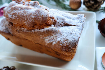 traditional christmas cake on a white table, fir branch, candles and christmas balls