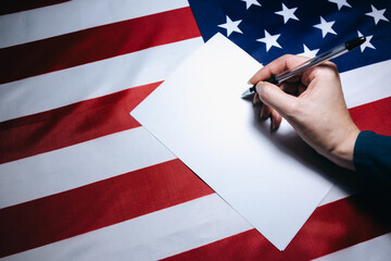 Woman putting tick on the paper for vote. Political changes in the country. Copy space place. Elections in the USA. American flag. People voting on ballot.
