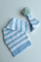 Various colors and types of cotton clothing, knitted newborn clothes and newborn hats on a white background.