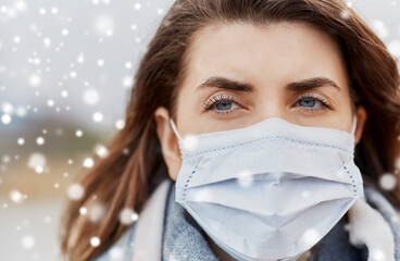 health, safety and pandemic concept - close up of young woman wearing protective medical mask outdoors in winter over snow