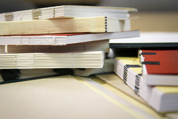 Close up photography of a pile of semifinished bound books in selective focus. Class work of...