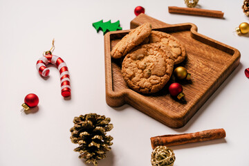 Cookies lie on a Board in the form of a house surrounded by Christmas toys and decorations, copyspace