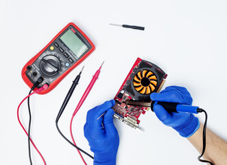 Hands of computer engineer doing repair damaged graphics card on isolated background. Concept of...