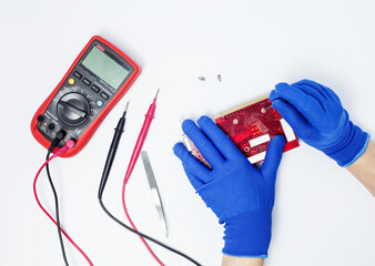 Hands of computer engineer doing repair damaged graphics card on isolated background. Concept of personal computer components maintenance and repair services. Top view.