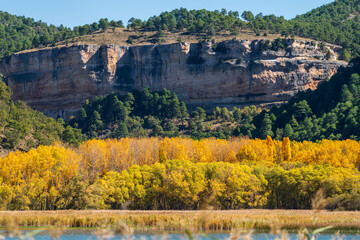 Autumn colors and huge cliffs over the lake