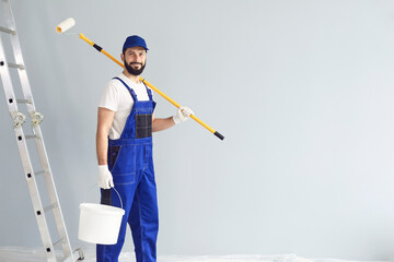 Positive painter with roller and bucket on gray background
