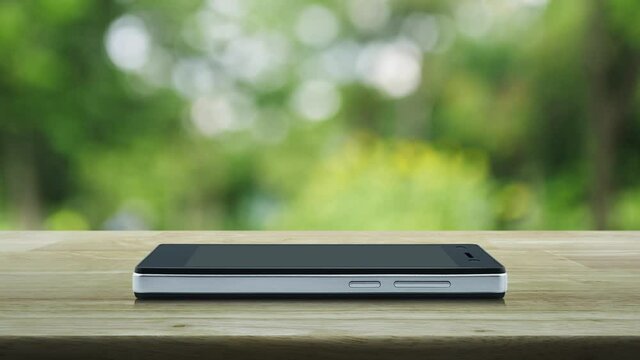 cctv camera flat icon on modern smart mobile phone screen on wooden table over blur green tree in park, Business security and safety online concept