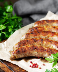 Fried sausages. Grilled sausages with spices on a wooden serving Board. Delicious meat sausages