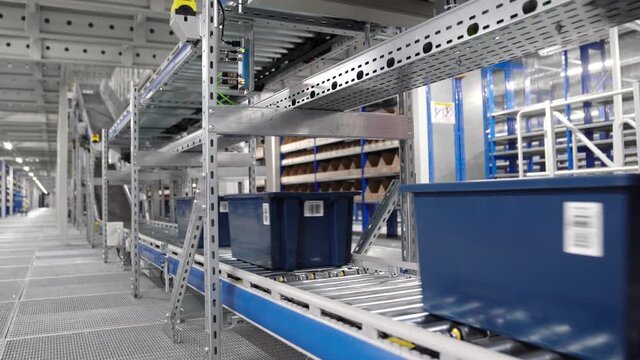 conveyor belt with blue boxes in warehouse of online store.