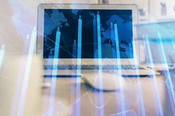 Financial chart drawing and table with computer on background. Multi exposure. Concept of international markets.