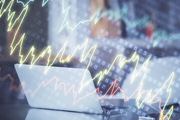 Stock market graph on background with desk and personal computer. Double exposure. Concept of financial analysis.