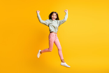 Fototapeta na wymiar Full size portrait of school person jump air arms fist up won stylish isolated on yellow color background