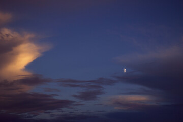 evening sky with clouds and a half of moon