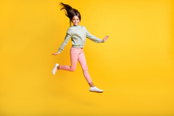 Fototapeta na wymiar Full body portrait of school person jumping hair fly happiness isolated on bright yellow color background
