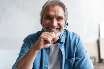 Head shot man sit on sofa in living room makes video call looks at camera, conversation by distant videocall, distance hiring job interview process, tutor and trainee study on-line concept