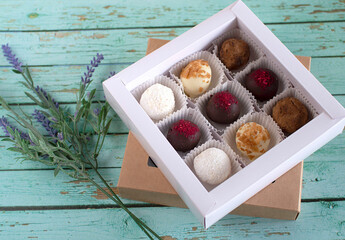 Homemade chocolate truffle candies on a wooden blue background. In a gift box. Chocolate round candies for the holiday