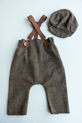 Various colors and types of cotton clothing, knitted newborn clothes and newborn hats on a white background.