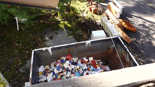 West Cornwall, Ct. USA A dumpster filled with discarded books at an old bookstore going out of business.