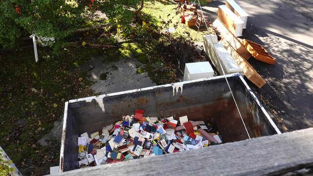West Cornwall, Ct. USA A dumpster filled with discarded books at an old bookstore going out of business.