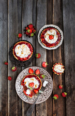 Fototapeta na wymiar Strawberry meringue tartlets on wooden rustic background