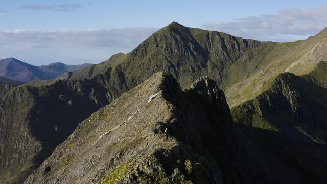 A man walking Crib Goch ridge, a dangerous mountain in Snowdonia