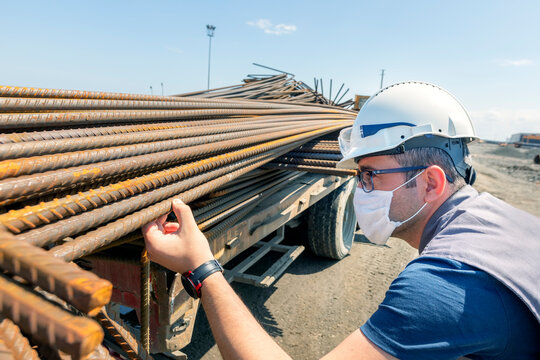 The inspector is checking to rebars in the construction site. Rebar (short for reinforcing bar), known when massed as reinforcing steel or reinforcement steel.