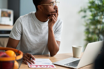 Thoughtful black man voting by mail