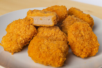 Chicken nuggets on a white plate, with ketchup