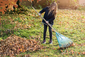 cute little girl playing collecting leaves in the garden