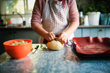 Teen girl kneading dough for apple pie, cozy autumn recipes, biscuit with apples