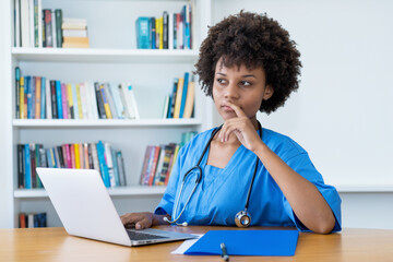 Thinking afro american nurse or medical student at computer