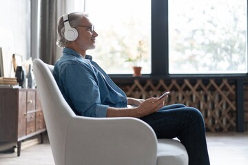 Man at home on sofa listening a music with a smartphone
