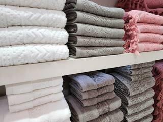 Terry towels of various colors are folded neatly on the shelves. Concept for lifestyle, retail,...