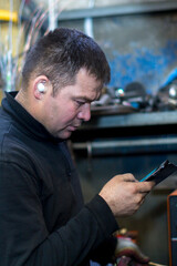 Close-up portrait of a man in the workplace with a mobile phone