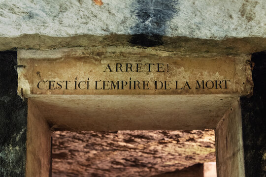 Entrance door of the catacombs of Paris, France. Text in French meaning: "Stop, here is the empire of death"