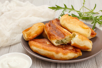 Plate with fried pies on wooden boards.