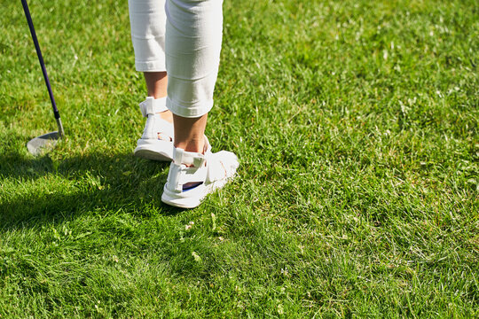Golfer in trendy footwear on the green grass