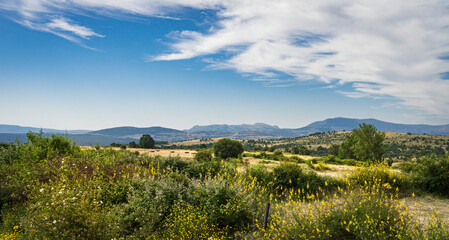 Obraz premium Panoramic view in late spring of the rural area of ​​the town of Braojos in Madrid with blue sky and white clouds.
