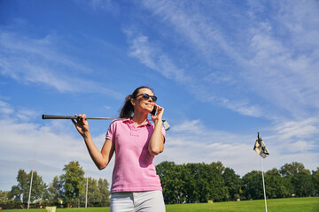 Smiling sporty lady having a phone conversation outside