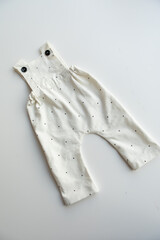 Various colors and types of cotton clothing, knitted newborn clothes and newborn hats on a white background.