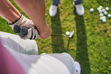 Sportswoman holding a golf putter with both hands