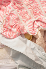 detail of adorable antique pink and white baby clothes and textiles at the flea market