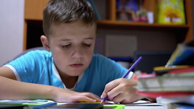 Boy Draws with Colored Pencils at Home. Home Schooling, Education Concept.