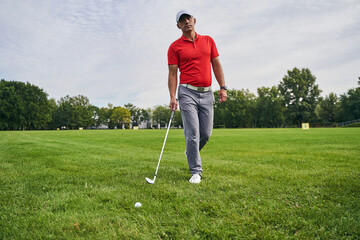 Fototapeta premium Sporty man carrying a wedge golf club