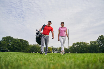 Pleased female golfer staring at her golf instructor